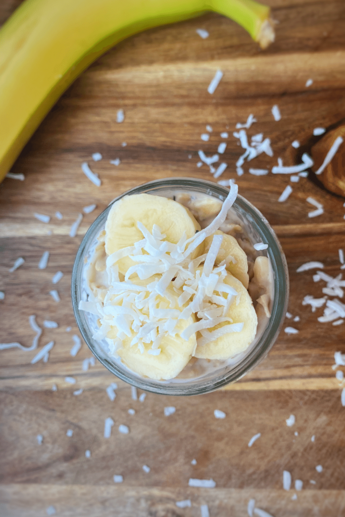 Photo of high calorie overnight oats with banana and shredded coconut.