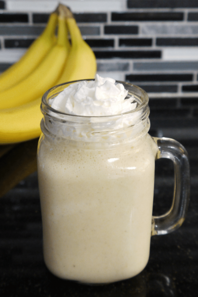 High calorie banana shake with banana in background.